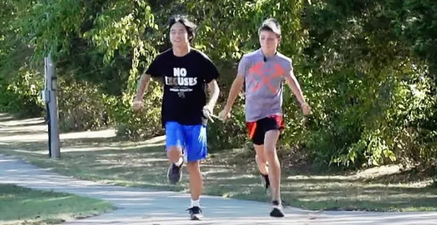 Un garçon de 12 ans guide son ami aveugle de 18 ans vers la ligne d'arrivée lors de courses à pied